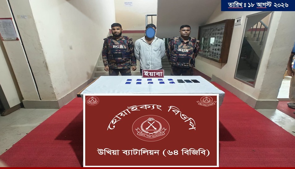 Two BGB officers stand behind a table with a detained individual, displaying seized items during an anti-smuggling operation in Ukhiya.